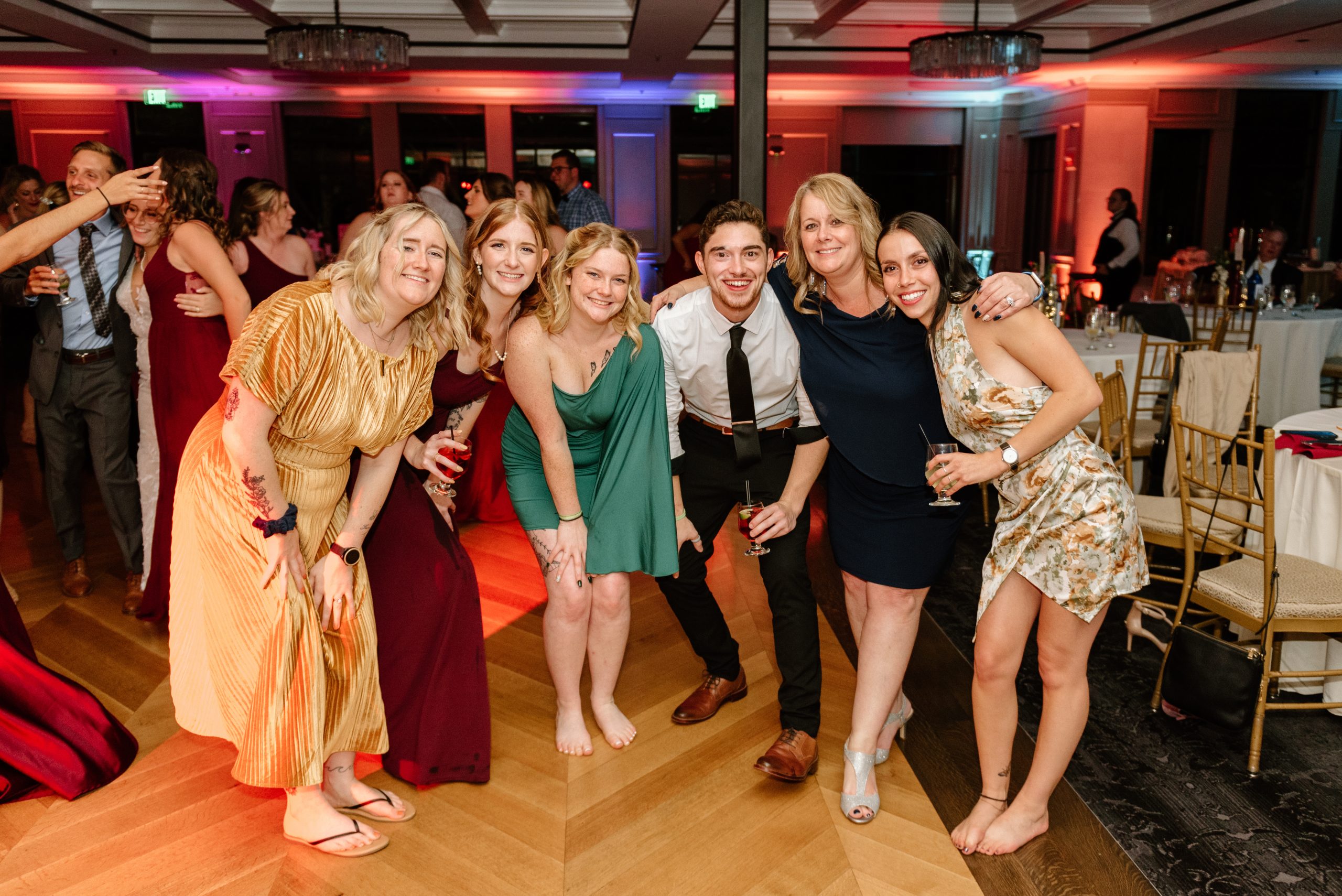 Wedding guests dancing together on a warmly lit dance floor